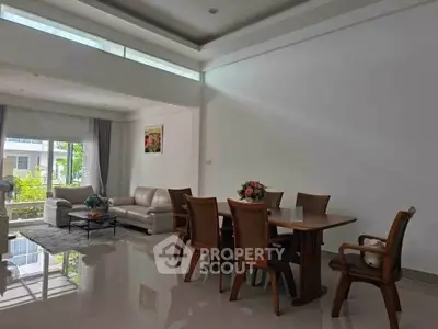 Spacious living and dining area with modern furniture and large windows.