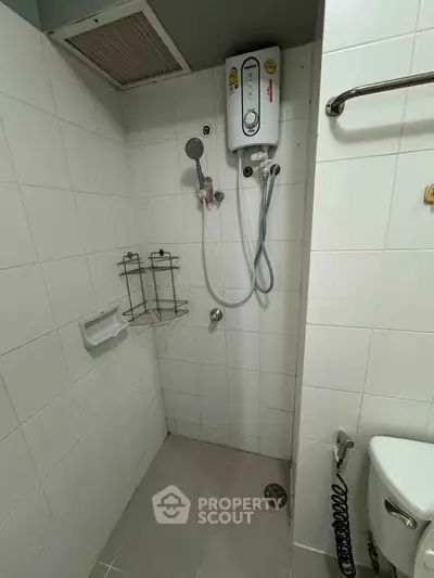 Compact bathroom with shower and water heater in modern apartment