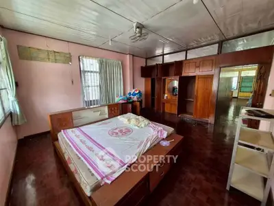 Spacious bedroom with wooden furniture and ample natural light