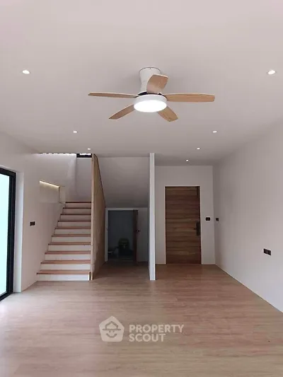 Spacious modern living room with wooden flooring and ceiling fan