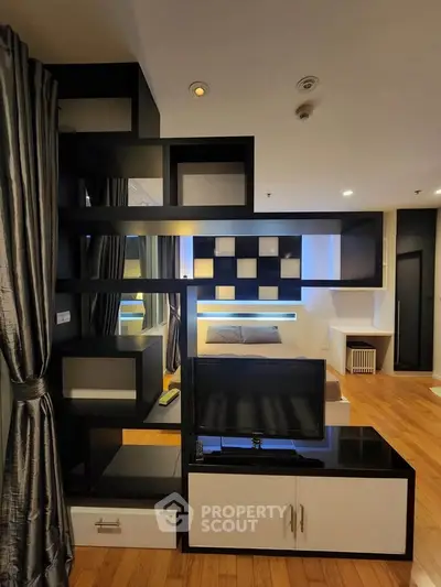 Modern studio apartment with stylish partition and cozy bedroom area, featuring sleek design and warm lighting.