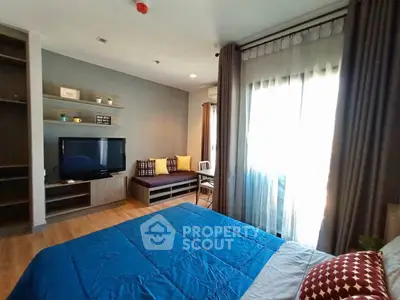 Modern bedroom with cozy seating area and large window for natural light.