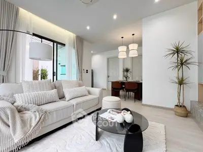 Modern living room with elegant decor and open layout, featuring cozy seating and stylish lighting.