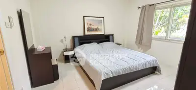 Cozy bedroom with modern furniture and large window offering natural light.