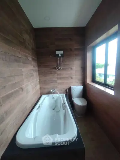 Modern bathroom with elegant bathtub and wooden wall accents