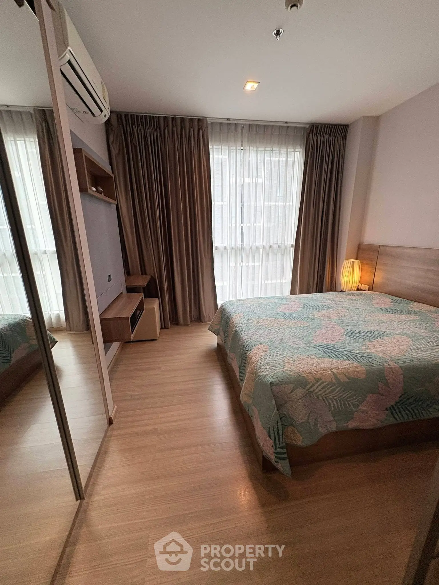 Cozy bedroom with large window, stylish curtains, and modern decor in a well-lit apartment.
