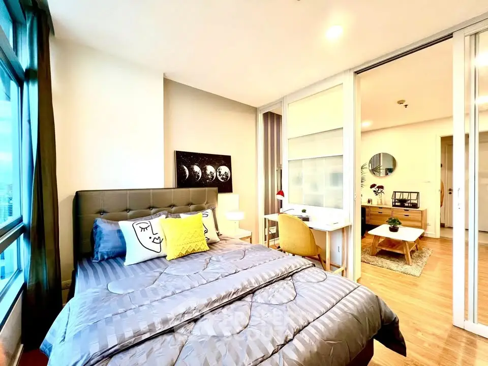 Modern bedroom with stylish decor and adjoining study area in a bright apartment.