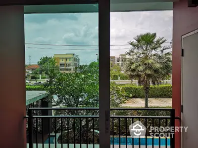 Scenic view from balcony overlooking lush greenery and modern buildings