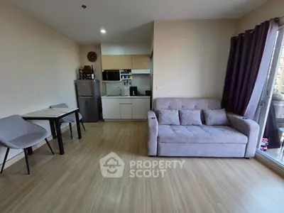 Modern living room with cozy sofa and compact kitchen in open layout apartment.