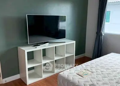 Cozy bedroom with modern TV setup and stylish decor