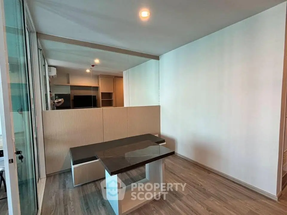 Modern living room with sleek design and wooden flooring, featuring a stylish table and ample natural light.