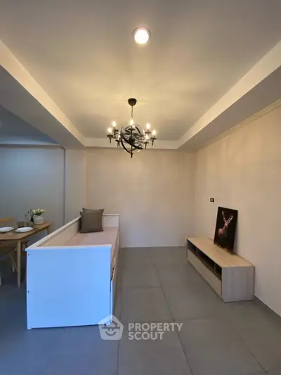 Modern living room with elegant chandelier and minimalist furniture