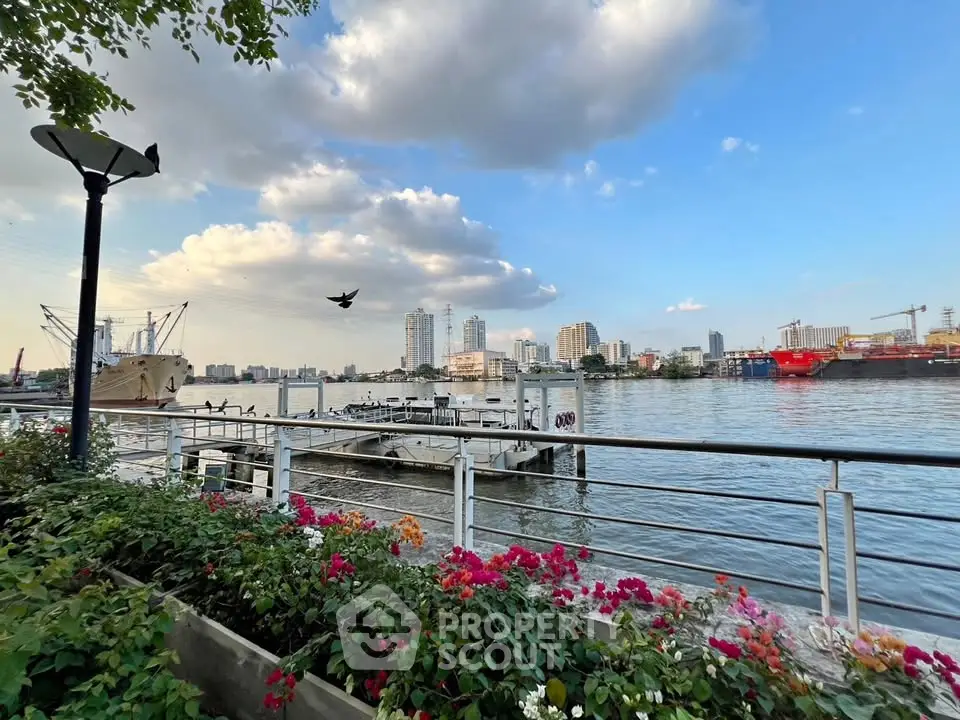 Stunning waterfront view with city skyline and vibrant flowers, perfect for urban living enthusiasts.