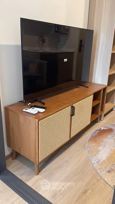 Modern living room with stylish wooden TV stand and flat-screen television.