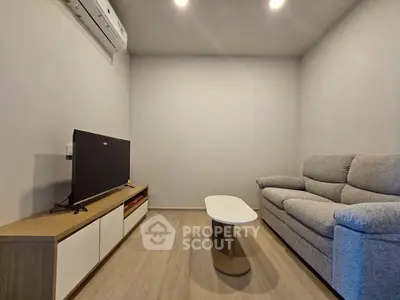 Cozy living room with modern sofa and TV setup, perfect for relaxation.