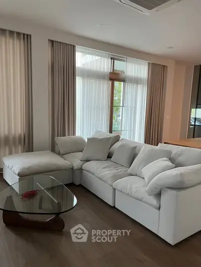 Spacious living room with modern white sectional sofa and glass coffee table