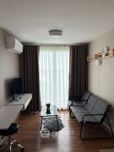 Modern living room with sleek furniture and large window, perfect for natural light.