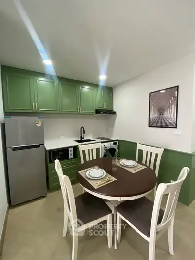 Charming kitchen with green cabinets and dining area in modern apartment