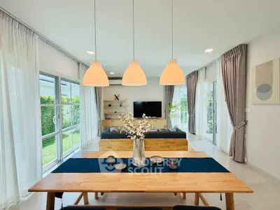 Spacious modern living room with elegant dining area and garden view, perfect for family gatherings.