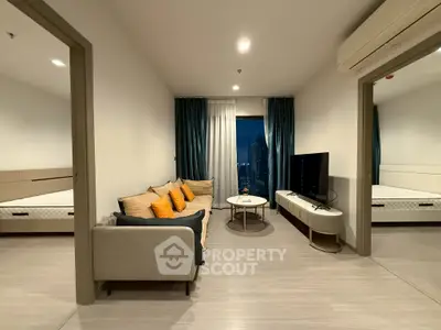 Modern living room with city view, stylish sofa, and large TV, perfect for urban living.