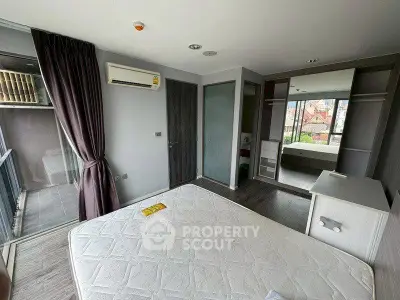 Spacious bedroom with balcony access and mirrored wardrobe in modern apartment.