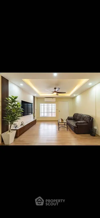 Modern living room with sleek design, wooden flooring, and cozy seating area.