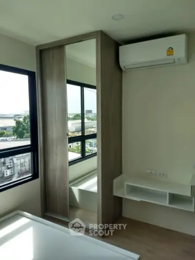 Modern bedroom with large windows and air conditioning in a high-rise apartment
