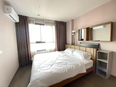 Cozy bedroom with natural light and modern furnishings in a stylish apartment.