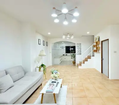 Spacious modern living room with cozy sofa and elegant staircase