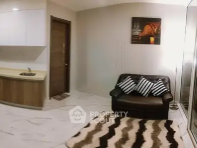 Modern living room with sleek kitchen, cozy sofa, and stylish decor in a contemporary apartment.