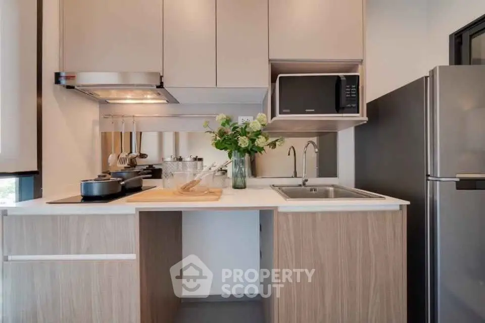 Modern kitchen with sleek cabinetry, stainless steel appliances, and elegant decor in a stylish apartment.