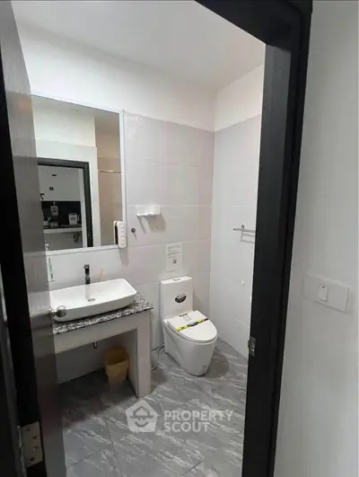 Modern bathroom with sleek fixtures and granite countertop in a contemporary apartment.