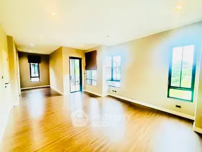 Spacious and bright living room with large windows and wooden flooring