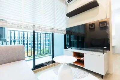 Modern living room with large TV and balcony view in a stylish apartment