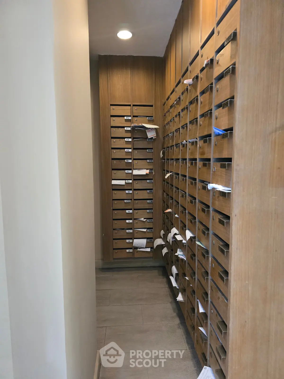Spacious apartment building mailroom with multiple mailboxes and modern lighting.