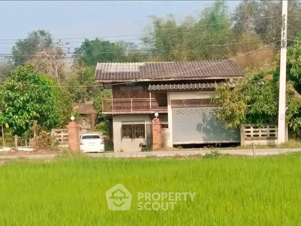 Charming rural house with lush greenery and spacious surroundings.
