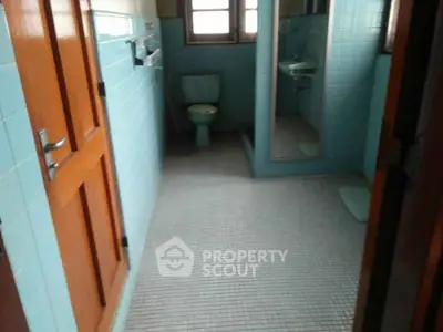 Vintage bathroom with blue tiles and classic fixtures, offering a nostalgic charm.