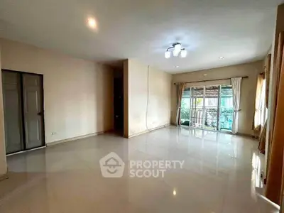 Spacious living room with large windows and modern lighting, perfect for family gatherings.