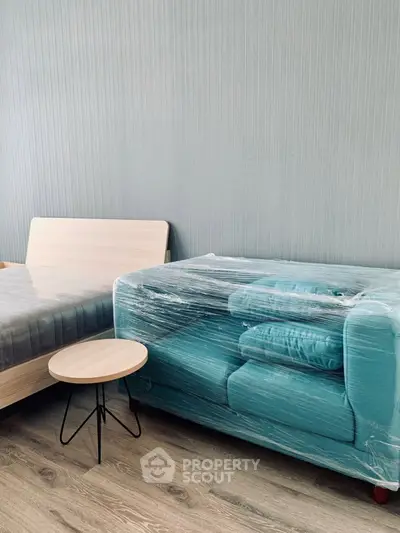 Modern bedroom with wrapped teal sofa and minimalist decor