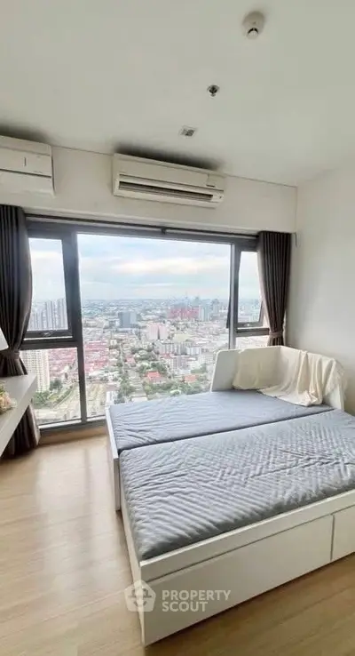 Modern bedroom with stunning city view from large windows, featuring cozy bed and air conditioning.