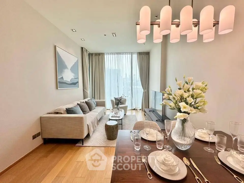 Elegant dining and living space with modern furnishings, hardwood floors, and chic pendant lighting, ideal for entertaining and relaxation.