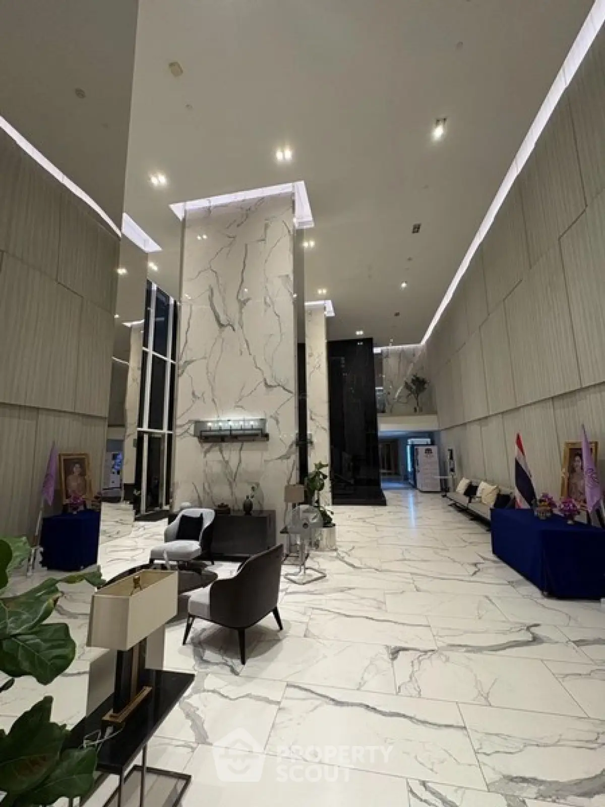 Luxurious modern building lobby with marble floors and elegant seating area.
