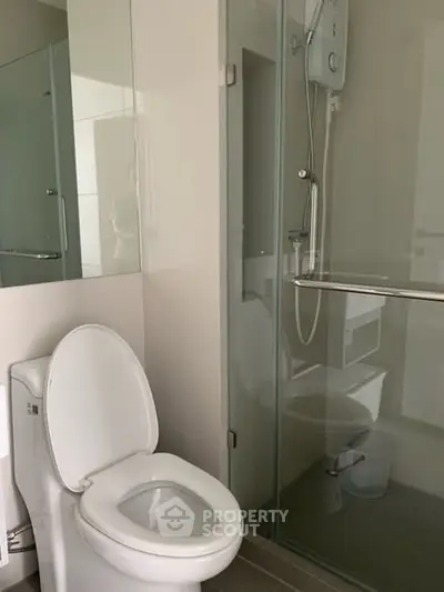 Modern bathroom with glass shower and sleek toilet design.