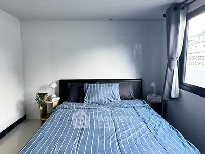 Cozy bedroom with striped bedding and natural light from window