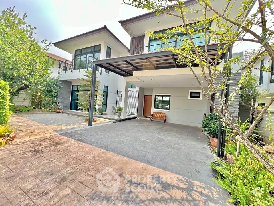 Modern two-story house with spacious driveway and lush greenery