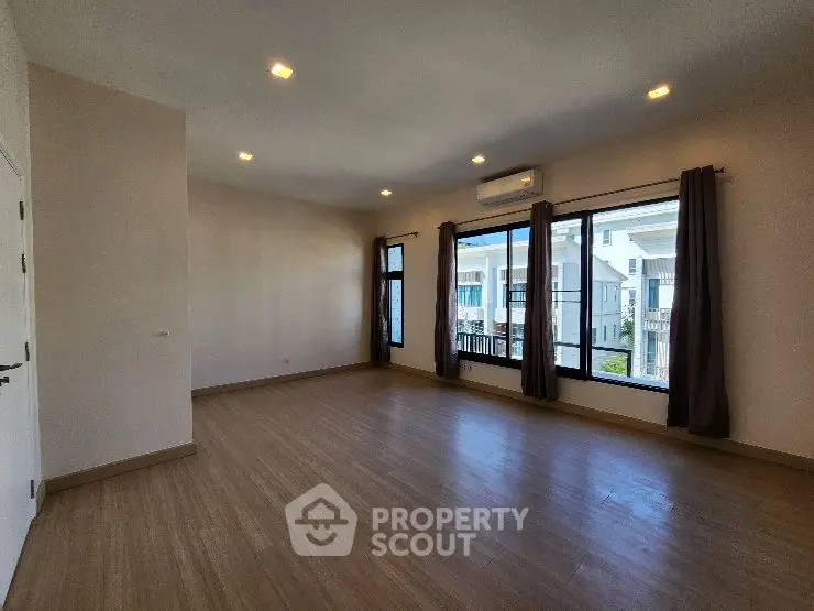 Spacious living room with large windows and modern flooring