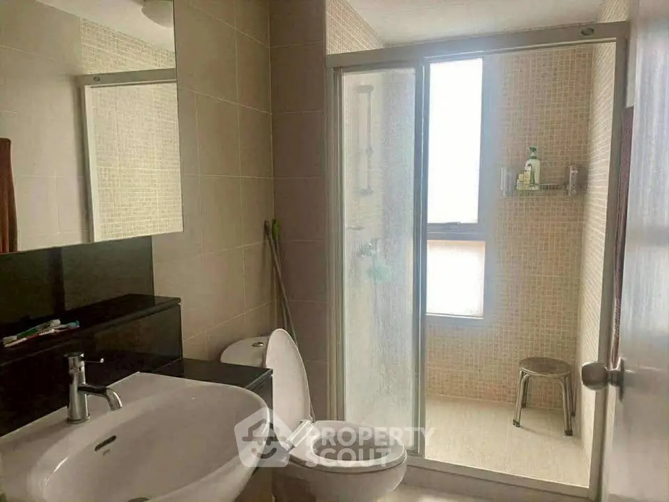 Modern bathroom with glass shower and sleek fixtures in a contemporary home.