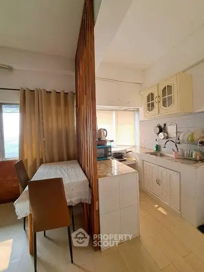Charming kitchen with dining area and natural light, featuring a cozy closed layout and modern appliances.