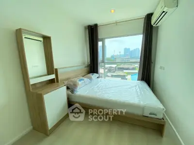 Modern bedroom with city view, featuring a sleek bed and air conditioning, perfect for urban living.