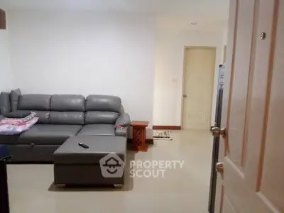 Spacious living room with modern gray sectional sofa and sleek flooring